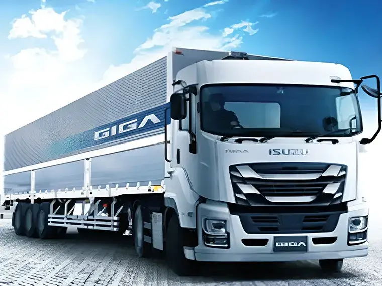 青空の下を走行する白色の大型トレーラー式輸送トラック(ISUZU GIGA)