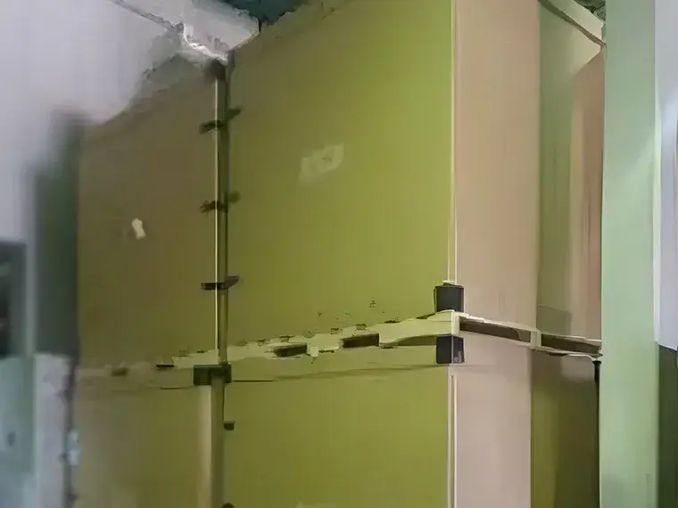 倉庫内で大型の荷物を縦積み固定用ベルトで固定している様子