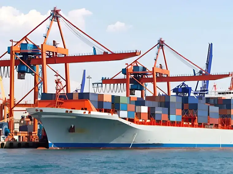 港でコンテナクレーンが稼働し、コンテナ船へ積み込み作業を行う様子