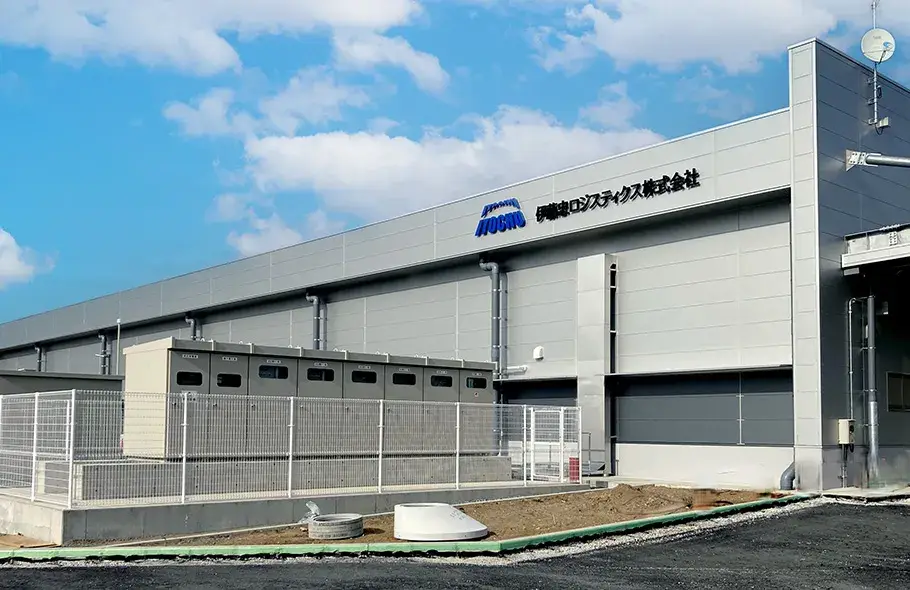 伊藤忠ロジスティクス株式会社の物流センター外観。近代的なグレーの建物で、社名とロゴが壁面に掲げられている。晴天の下、整備中の敷地とフェンスが写っている。