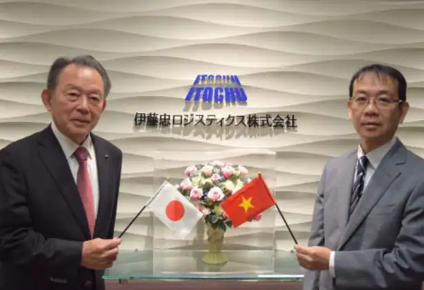 伊藤忠ロジスティクス株式会社のエントランスで、日章旗とベトナム国旗を手に並ぶスーツ姿の男性2人