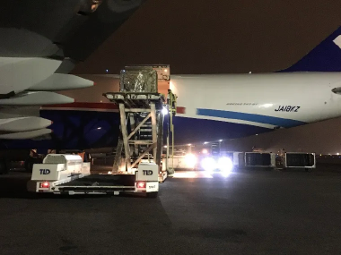 夜間の空港で貨物を搭載中の大型貨物機