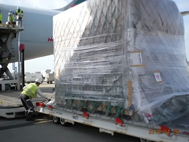航空機への積み込み前に大型貨物を固定する作業員