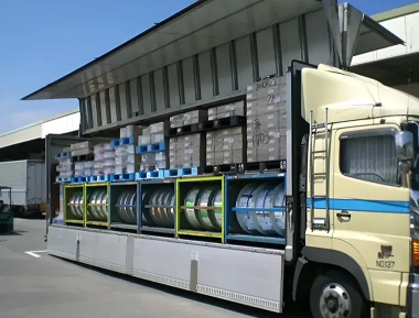 Metal coil and palletized cargo loaded onto a wing-body truck.